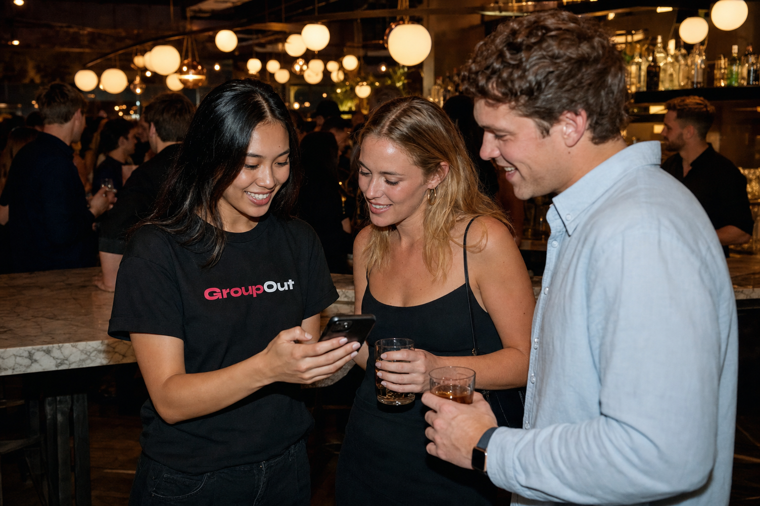 GroupOut ambassadors showing the app to people at a bar
